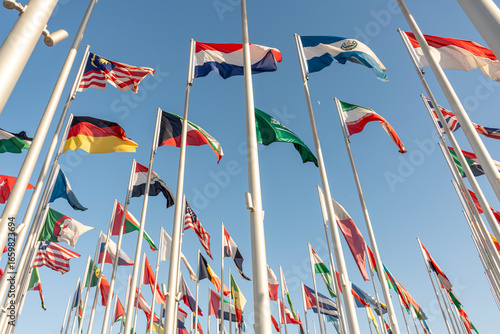 Doha, Qatar - 13 January 2025. Flags from various nations are flying high against a bright blue sky, showcasing global unity. The scene captures the essence of cultural diversity