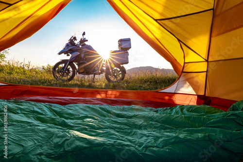 Motorcycle trip to the mountains with a tent. Beautiful sunset in the mountains.