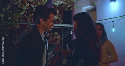 Wallpaper Mural Friends gather for a lively night party in a rustic backyard, enjoying good company, drinks, and party favors under colorful string lights. Torontodigital.ca