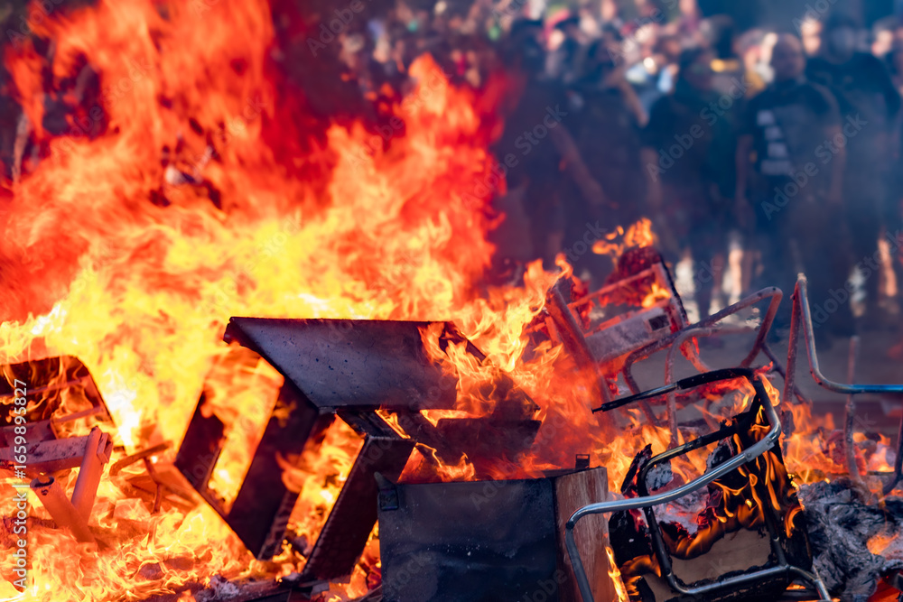 Obraz premium A fire is burning in a pile of chairs and other debris