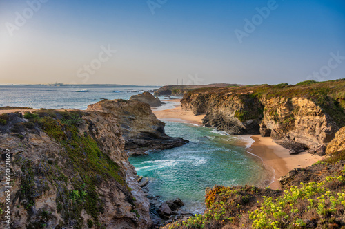 Rocky shoreline with waves at Praia da Samouqueira in Alentejo Portugal