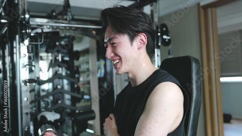 フィットネスジムで筋力トレーニングを行うスポーツウェアを着た若い日本人男性	