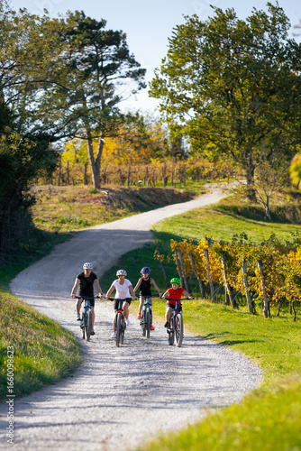 Family cycling through vineyards in Vipava Valley Slovenia