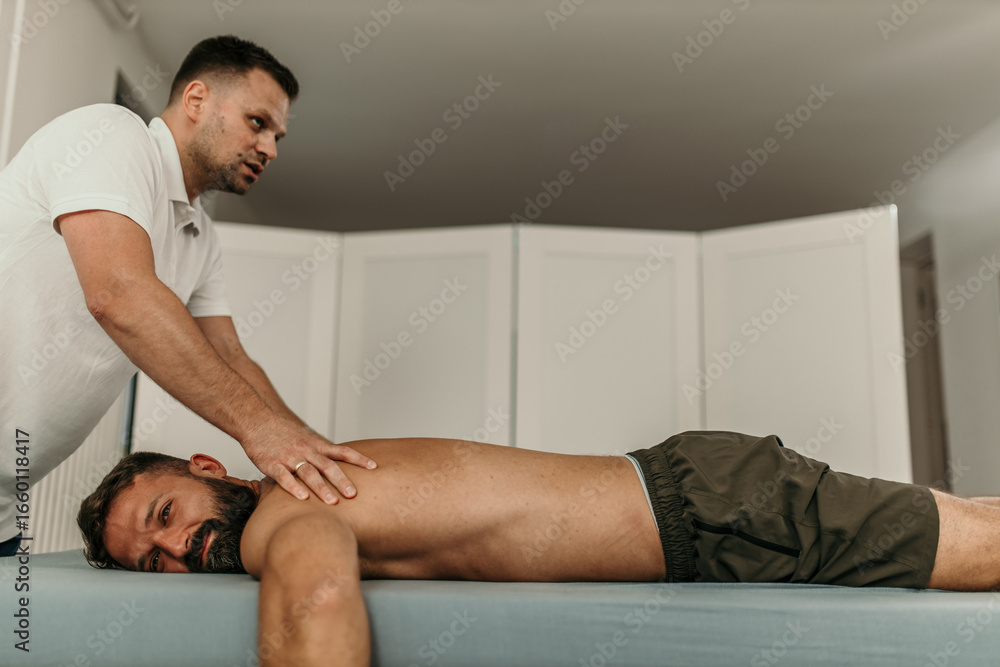 Fototapeta premium Physiotherapist giving back massage to patient in clinic