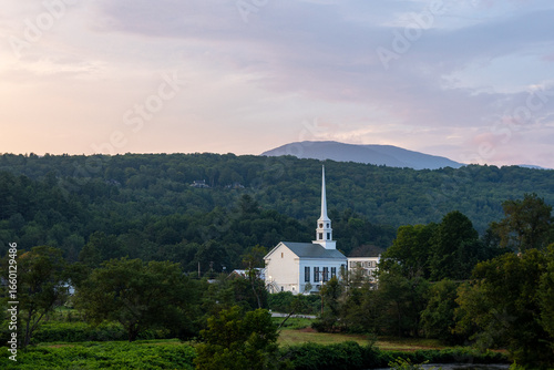 White church steeple with mountain backdrop in Vermont landscape
