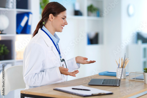 Wallpaper Mural Telemedicine. Doctor having video call with patient via laptop indoors Torontodigital.ca