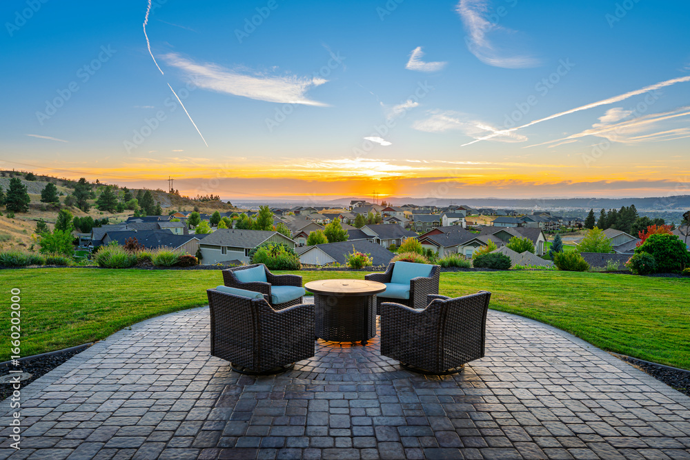 Φωτογραφία A patio set with chairs and firepit on a custom stone paver tiled terrace above the city of Spokane, Washington, USA at sunset