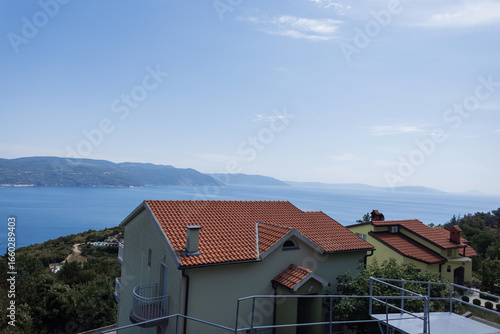 Wallpaper Mural Tranquil seaside panorama of Croatia, featuring blue waters, green hills, and charming red-roof homes. Peaceful seascape with gentle waves and wide horizon under a clear sky in Croatia. Torontodigital.ca