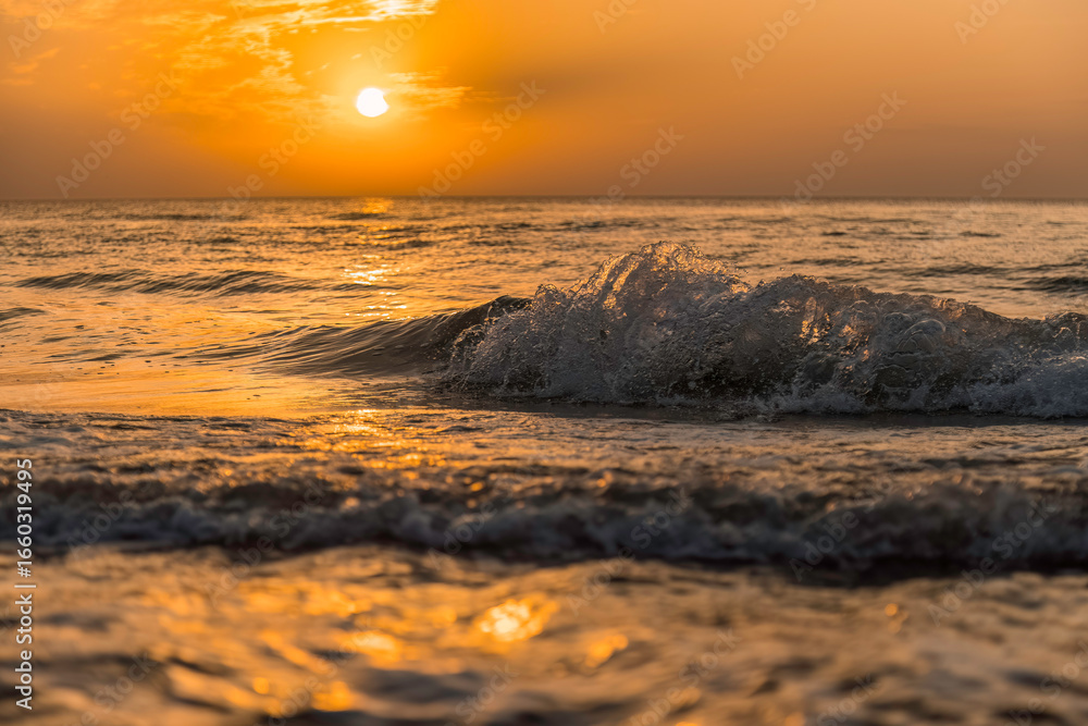 Naklejka premium Aufnahme von schönen Wellen und einem Sonnenuntergang am Meer.