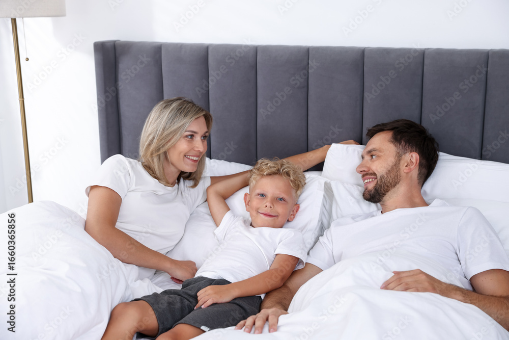 Fototapeta premium Happy family spending time together on bed at home