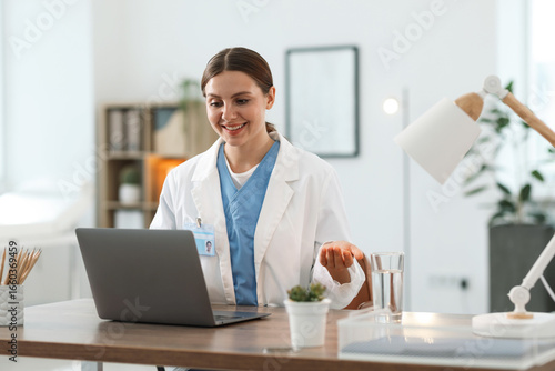 Wallpaper Mural Telemedicine. Doctor having video call with patient via laptop indoors Torontodigital.ca