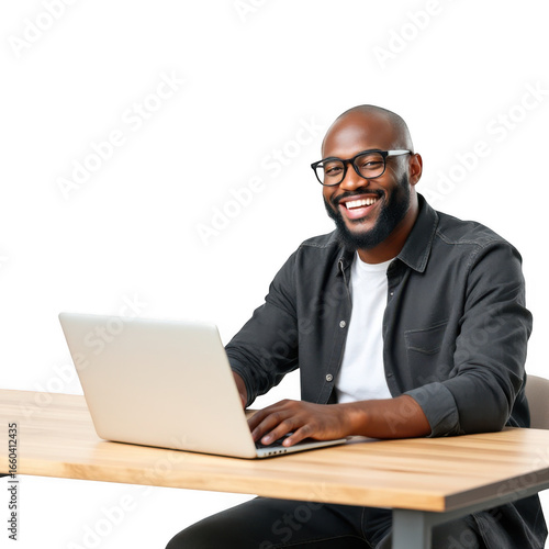 Smiling black man wearing glasses working on a laptop at a wooden desk isolated on transparent background