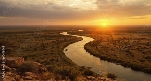 Curving river at sunset viewed from a rocky hillside
