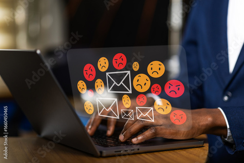 African businessman receiving negative emails on laptop, online harassment, spam, and bad customer feedback. Cyberbullying concept.