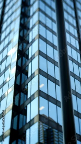 Wallpaper Mural The blurry high-angle shot shows the corner of a modern office building with a blue glass facade and a black cylindrical pillar Torontodigital.ca