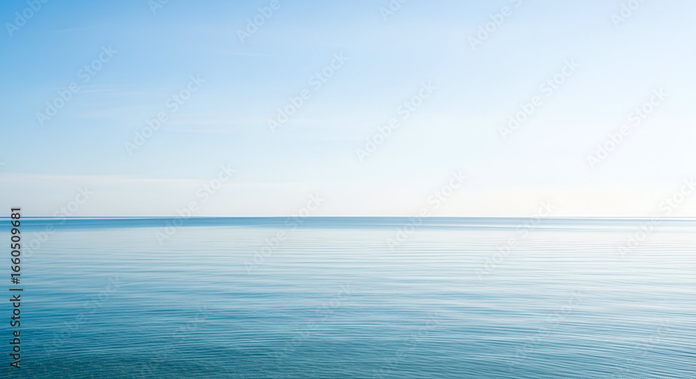 Obraz premium A wide-angle shot of calm blue ocean meeting a clear bright sky, minimalist composition, neat horizon line, clean natural background.