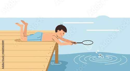 Boy Lying On Dock Trying To Catch A Fish With A Net In The Summer Time