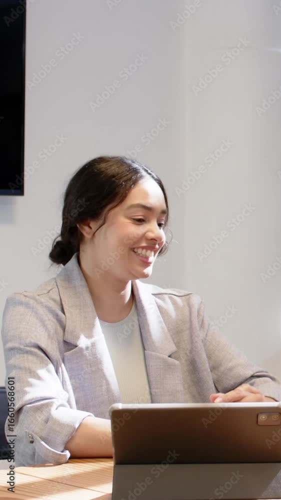 Vertical video: Mid adult woman hearing colleague comment, nodding gesturing with tablet at office Vertical video: Mid adult woman hearing colleague comment, nodding gesturing with tablet at office