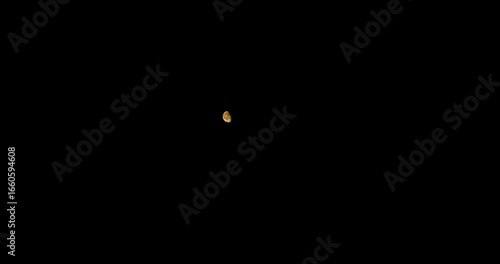 Timelapse of the full moon rising on a black night sky, moving steadily from left to right in ultra high definition 4K.