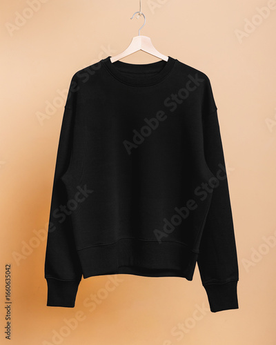 Black Cotton Sweatshirt for Mockup. High-quality black cotton sweatshirt hanging on a hanger. Studio image on a neutral background, perfect for design mockups.
