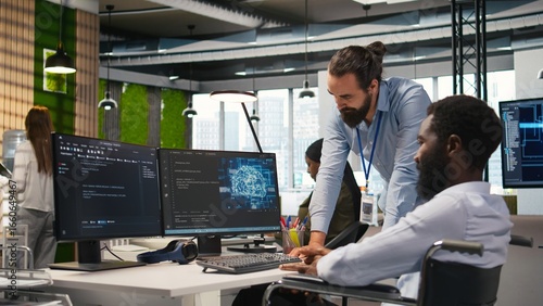 Startup engineer and colleague with paraplegia brainstorming, working with machine learning tech. Man in wheelchair and coworker in office transforming data into AI predictive models, camera A