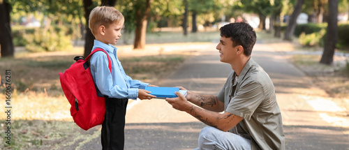 Father giving books to his ...
