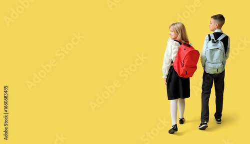 Little students with backpa...