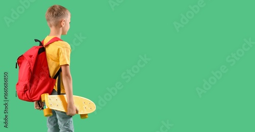 Little schoolboy with backp...