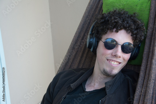 Obraz na płótnie Young man wearing sunglasses lying and relaxing in a hammock.
