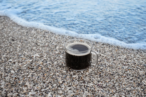 Glass mug of coffee on pebb...