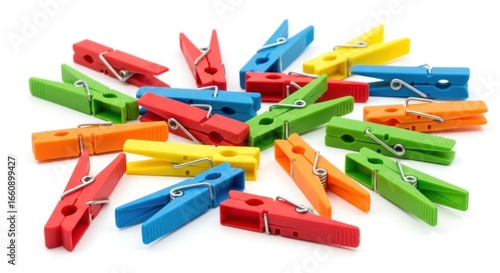 Scattered colorful plastic clothespins lay haphazardly on a white surface, creating a vibrant and playful arrangement