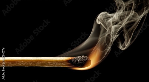 Close-up of a burning matchstick with smoke.