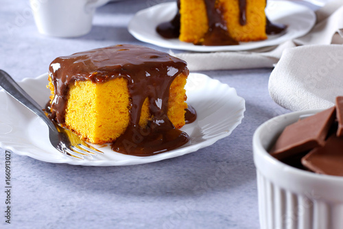 Slice of carrot cake with chocolate frosting on a ceramic plate. homemade Brazilian dessert