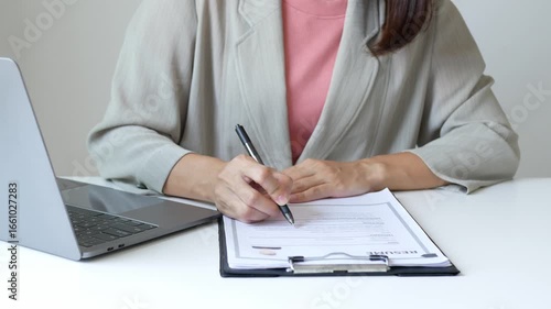 Young businesswoman holds a resume and evaluates it. Views the personal history of job applicants. Recruitment concept.