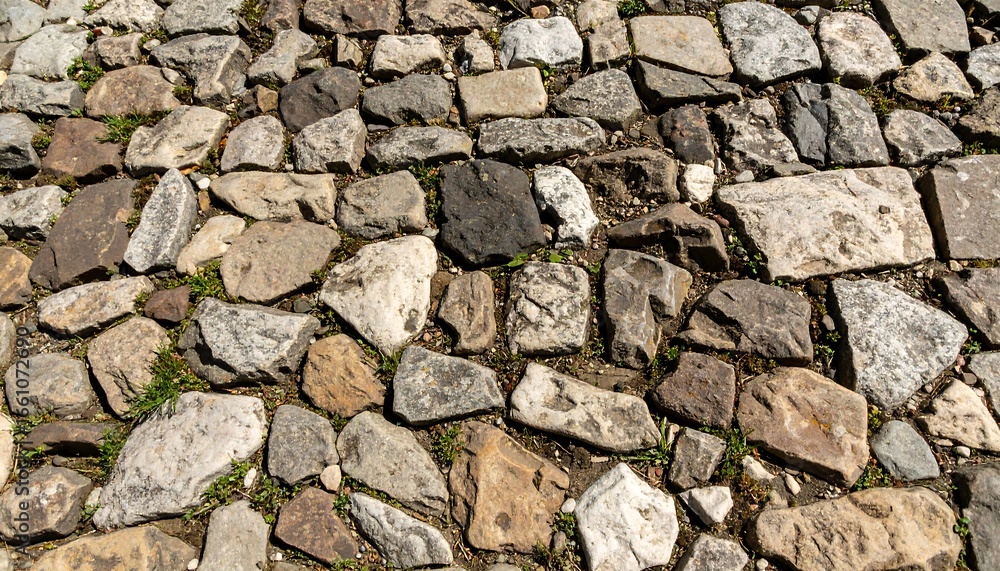 Fototapeta premium A textured surface of uneven, multicolored stones