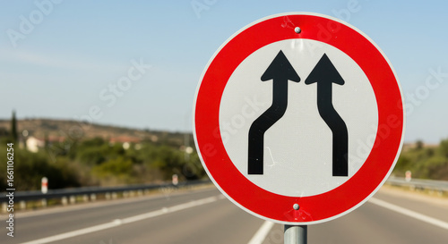 Road sign indicating lanes merge together ahead traffic will be reduced to one lane