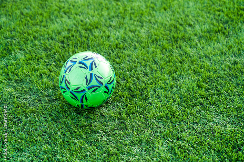 Fototapeta premium Soccer ball resting on synthetic field artificial green surface
