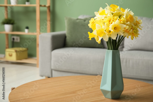 Fotografie Vase with beautiful daffodils on table in living room