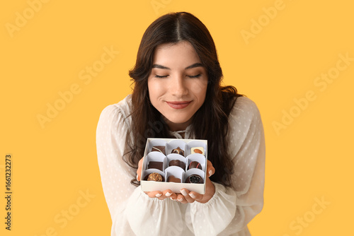Young woman smelling box of...