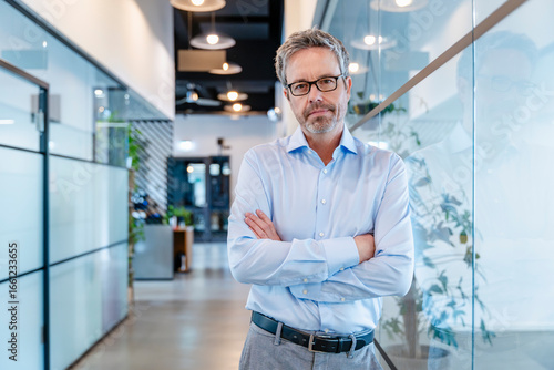 Wallpaper Mural Business executive with glasses standing confidently in modern office Torontodigital.ca