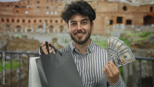 Photography Young man with beard holding shopping bags and us dollars at roman ruins on a sunny day outdoors, smiling and showing contentment