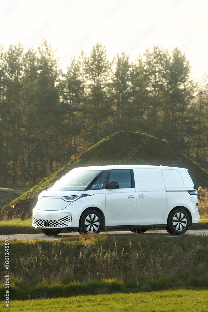 White commercial van driving near forest White commercial van driving near forest