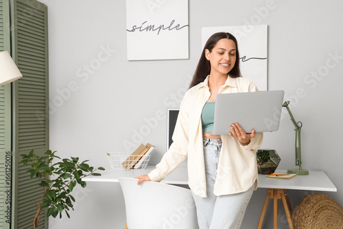Young woman with laptop and...