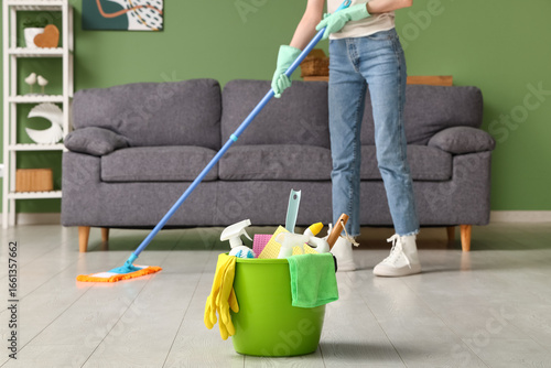 Young woman mopping floor i...