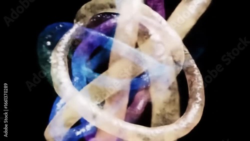 A close-up, abstract shot of intertwined translucent tubes or ribbons with varying colors of blue, purple, and beige against a dark background, creating a luminous and fluid composition.