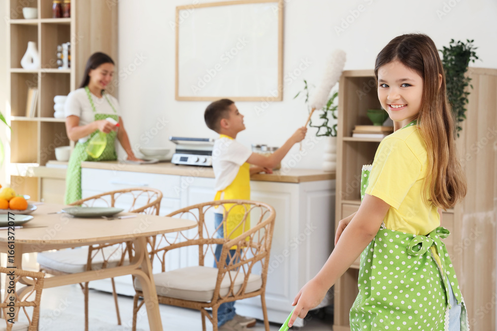 Fototapeta premium Teenage girl with her family cleaning in kitchen