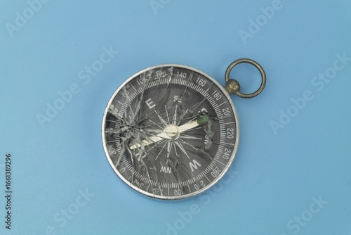 Broken compass on blue background. 