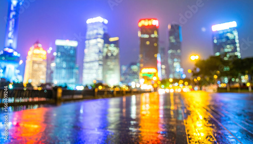 Rainy night street illuminated by car headlights with reflections on wet pavement in a city setting
