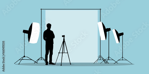 Silhouette of a photographer in a professional studio with a camera, backdrop, and softbox lighting equipment.