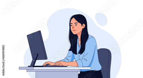 Focused young woman working diligently on her computer at a modern office desk, illustrating productivity, remote work, or professional tasks.